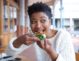 woman-eating-veggie-pizza